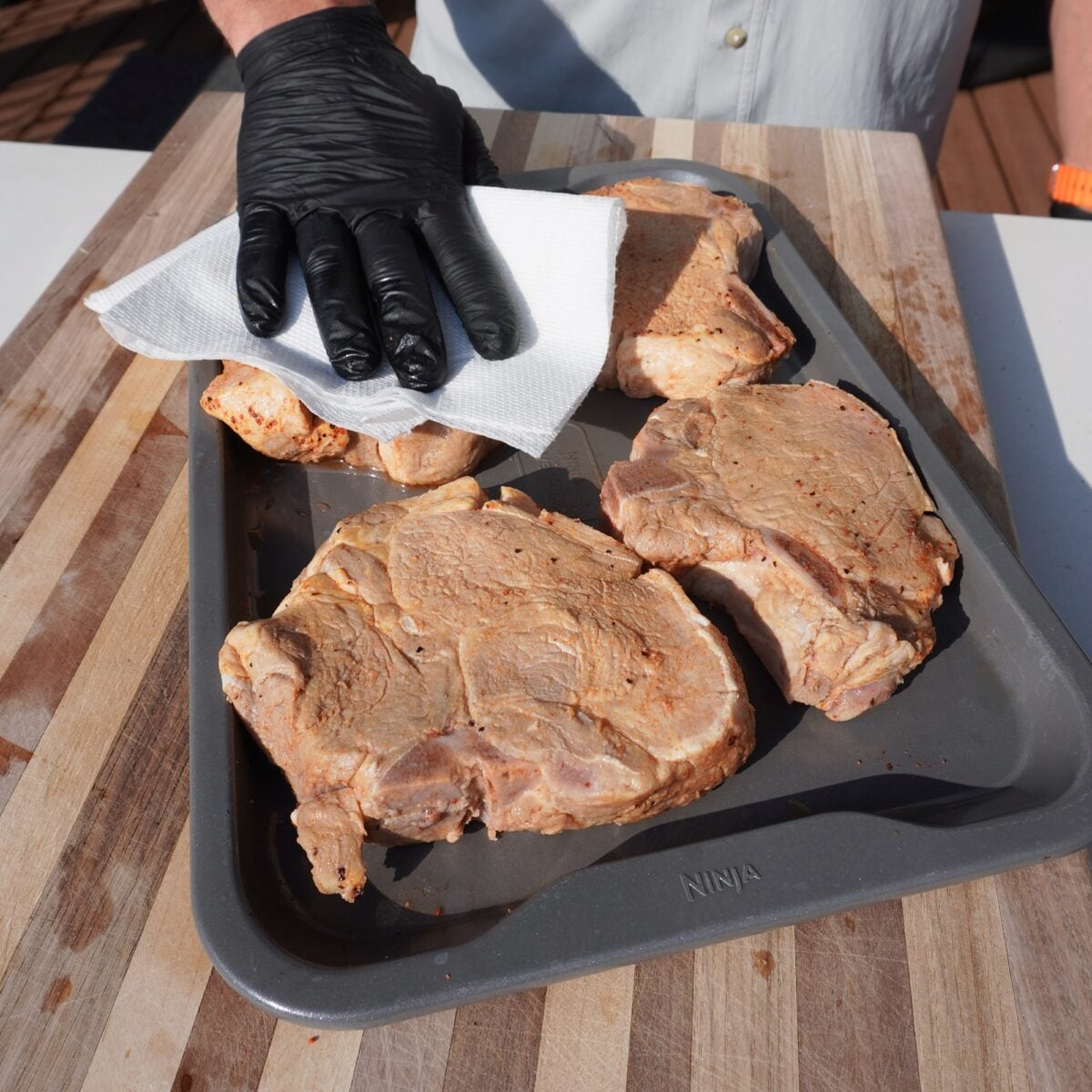 patting dry brined pork chops.