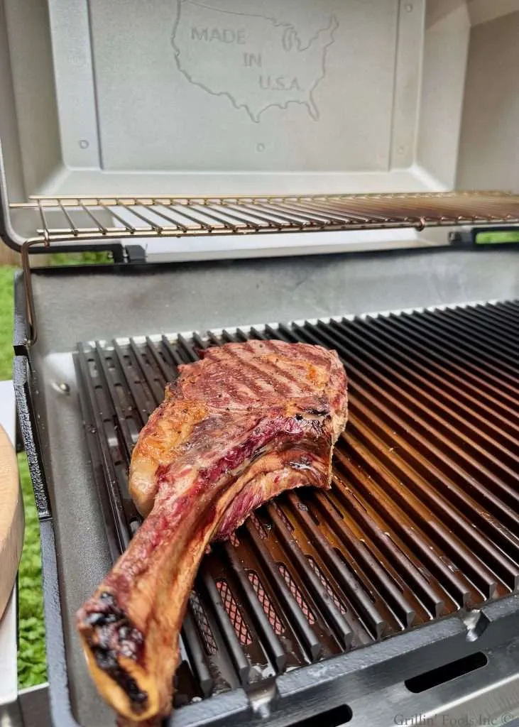A charred tomahawk on a MHP hybrid grill over the sear station