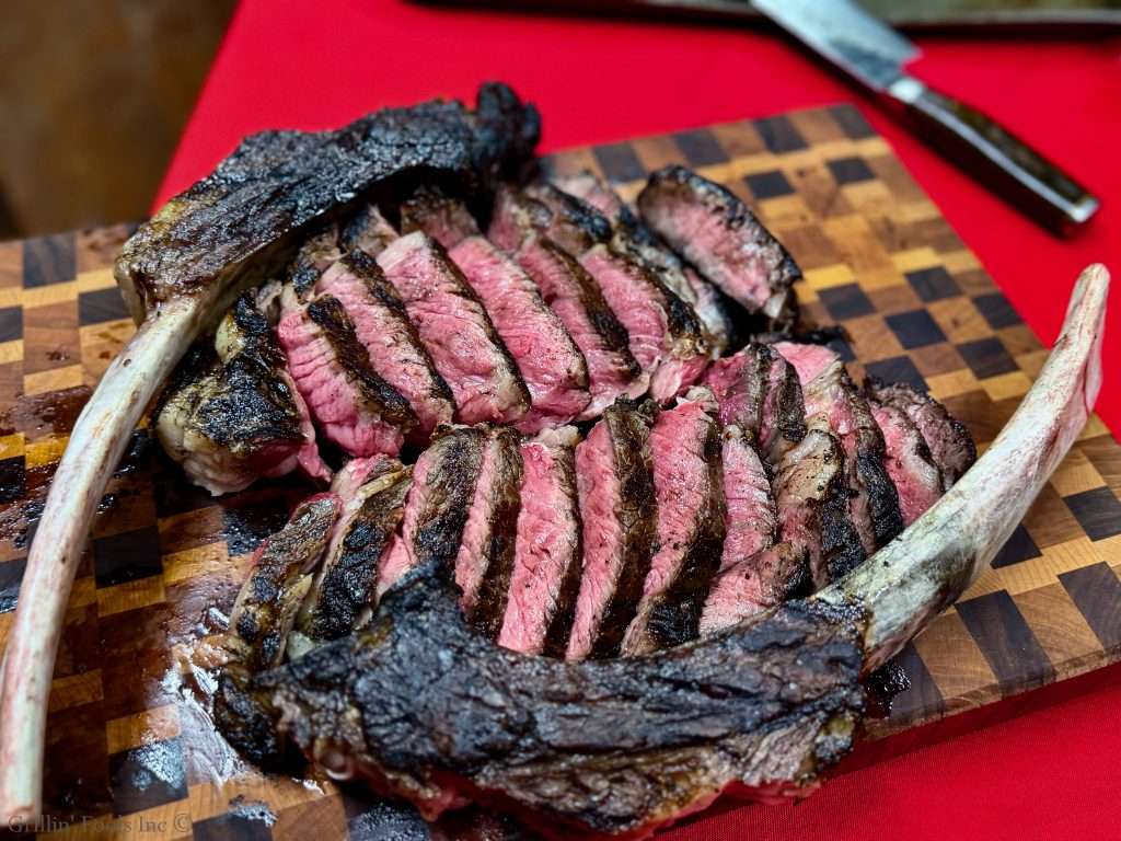 Two medium rare tomahawk steaks, meat removed from the bone and sliced
