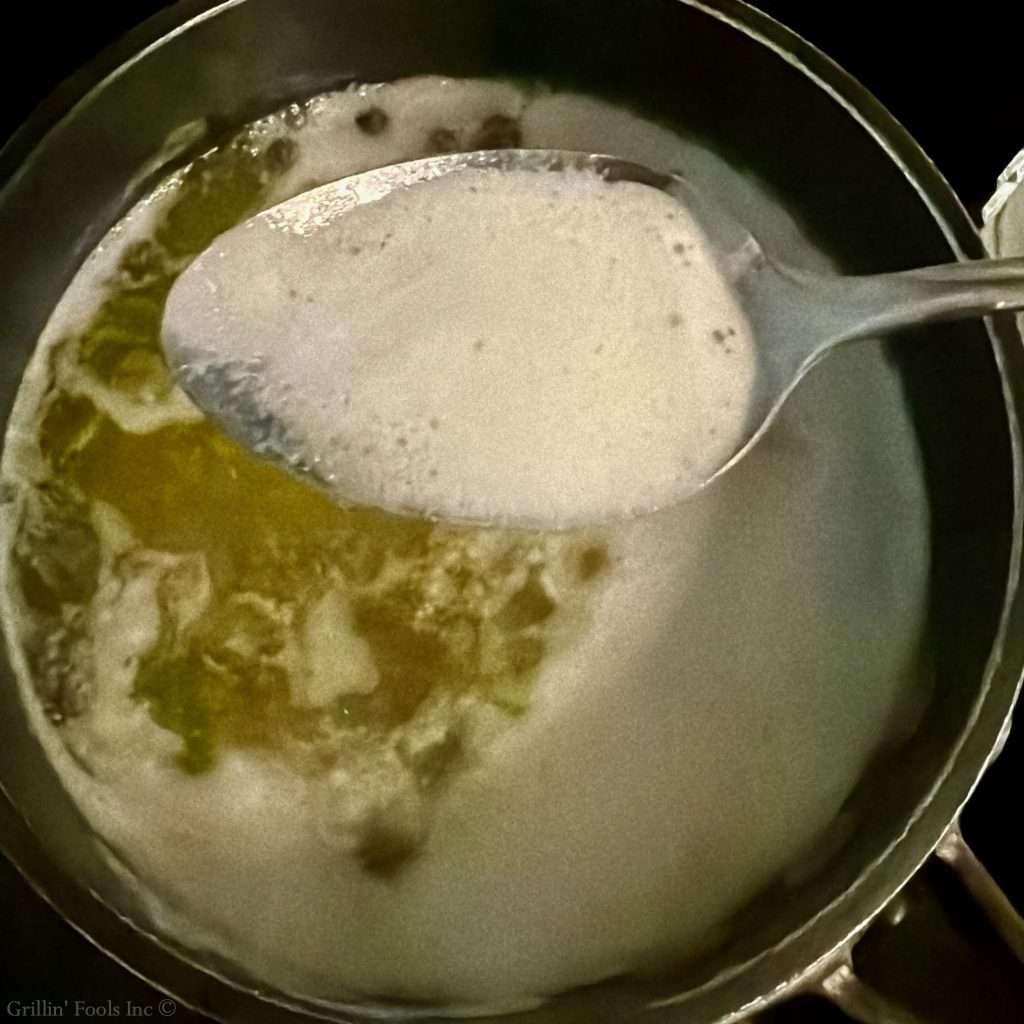 Close-up of a pot viewed from above, showing the solids being removed to make clarified butter Close-up of a pot viewed from above, showing the solids being removed to make clarified butter