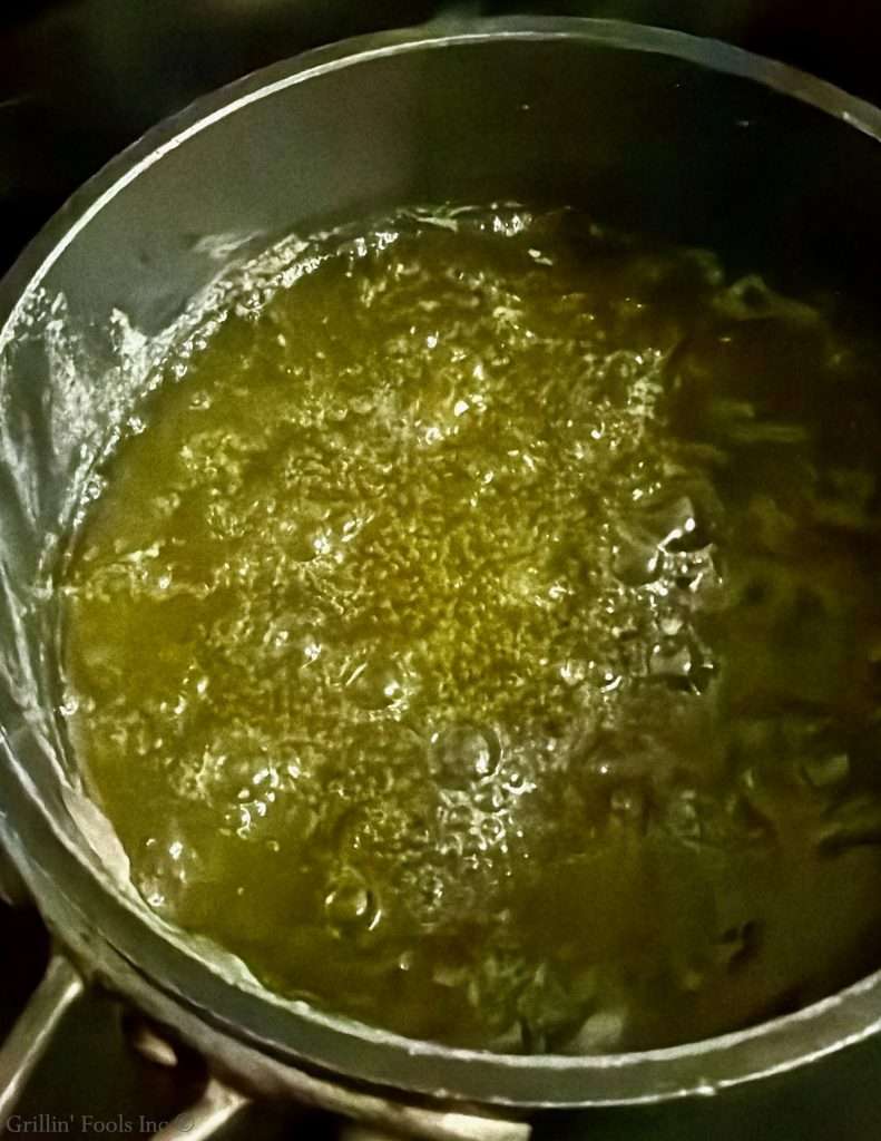 Pot/pan on a stove with a simmering clarified butter