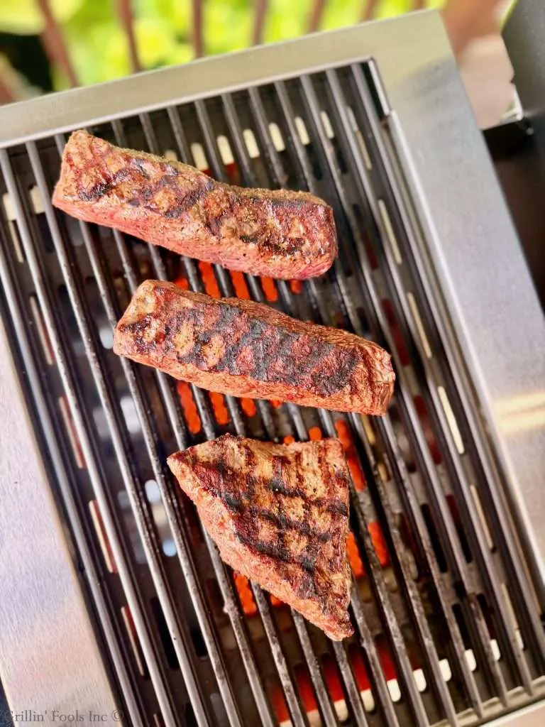 Three rump cap steaks on the grill with excellent cross hatch grill marks