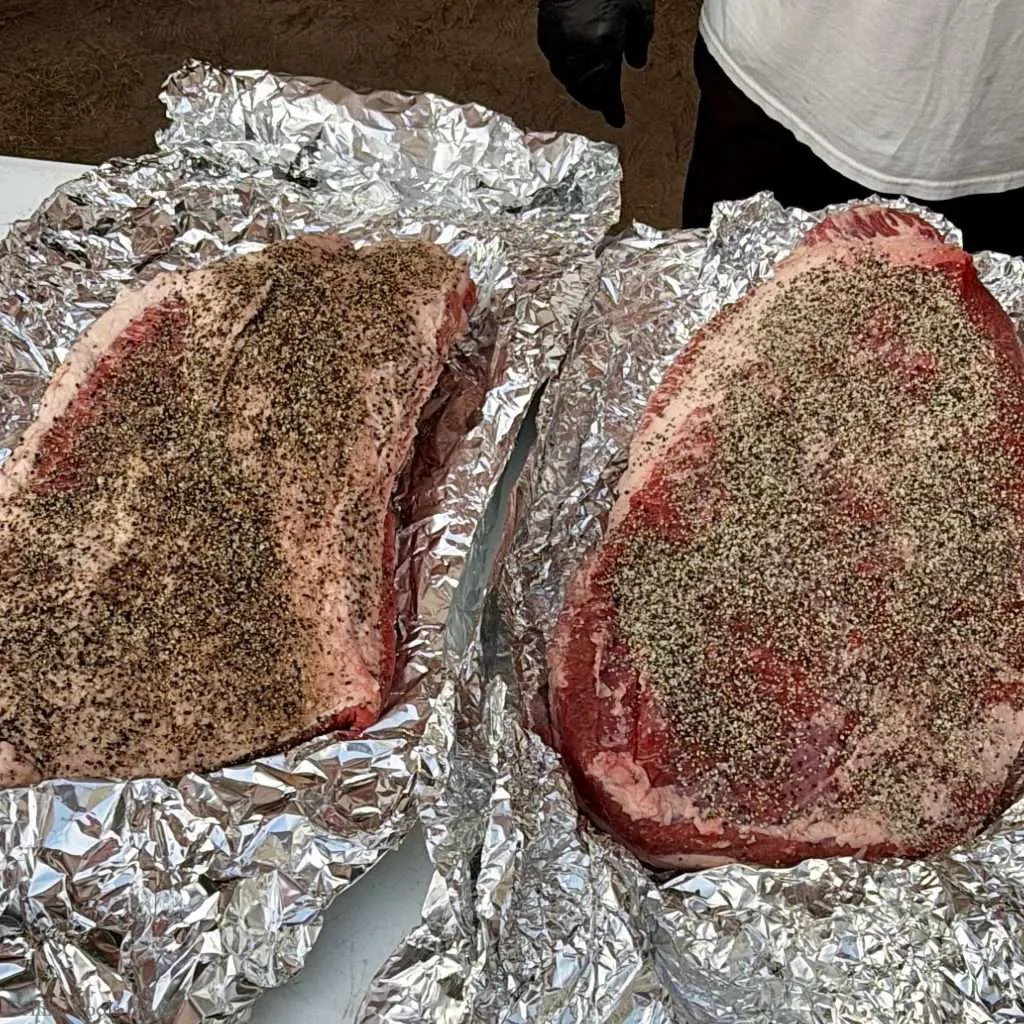 Two beef briskets seasoned with SPG, both on a bed of aluminum foil, the one on the left got a dry brine overnight