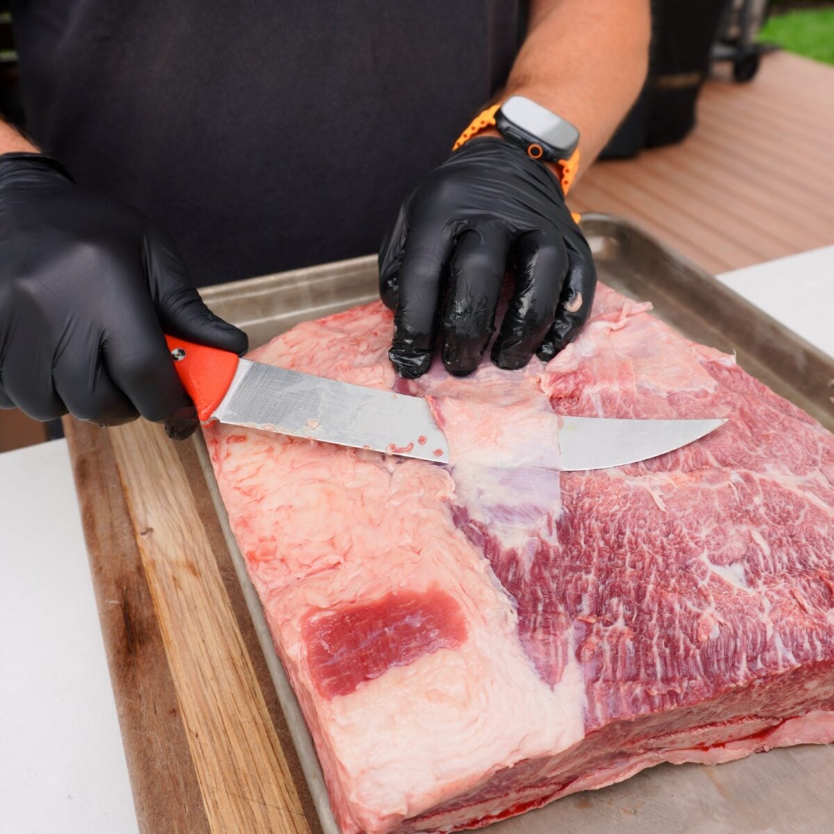 Removing fat and sliver skin off beef ribs.