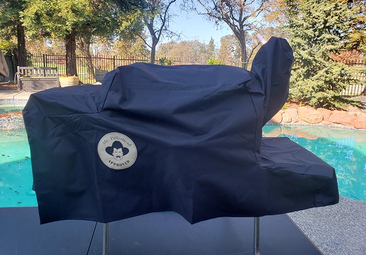 pellet grill covered with a black protective cover