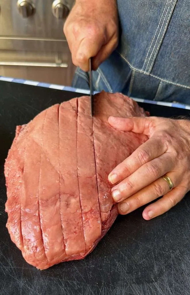 Carving parallel lines in the fat cap of a picanha roast