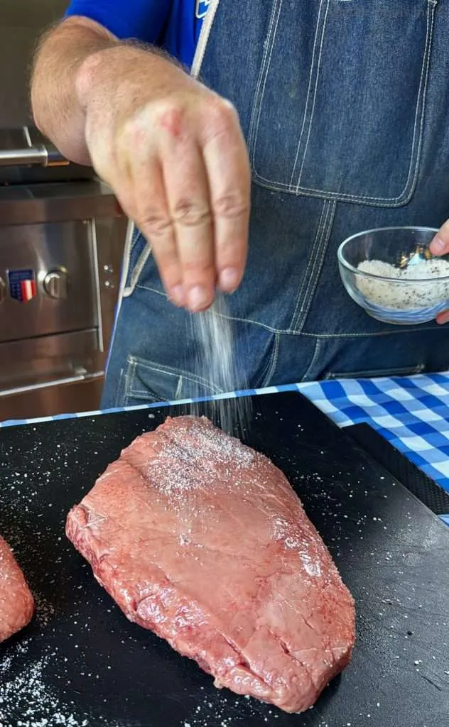 Seasoning a picanha roast on the fat cap side