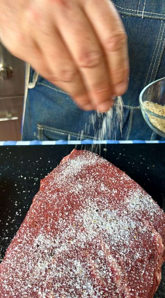 Seasoning a picanha roast on the meat cap side Seasoning a picanha roast on the meat cap side