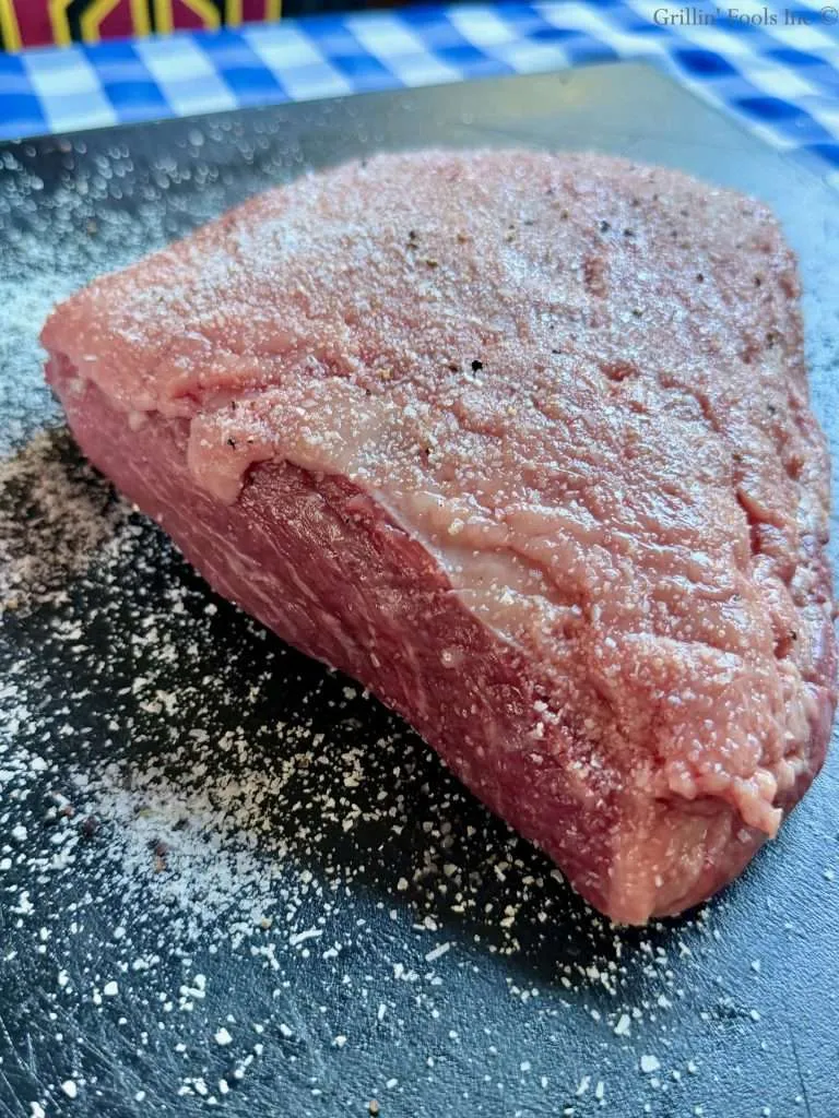 The side of the picanha roast that needs to be seasoned