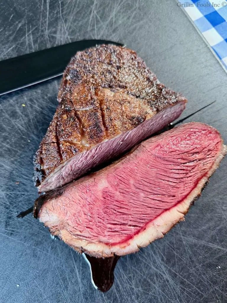 A rare picanha roast, sliced in half with one half of it facing up and the pic was taken from above.