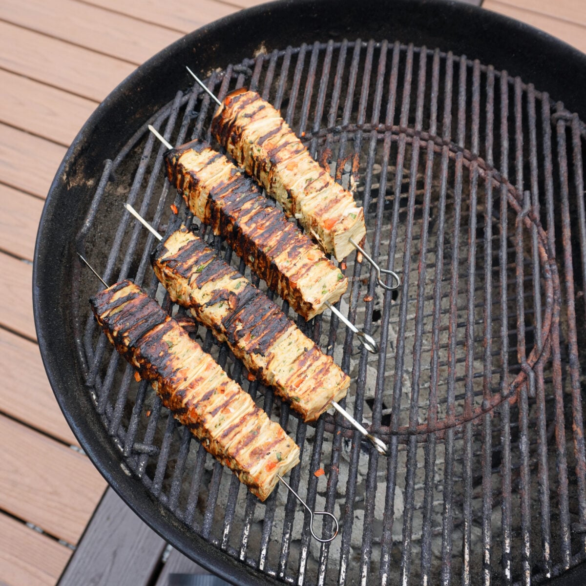 Chicken Shawarma Tortilla Kebabs grilled on a charcoal kettle grill.