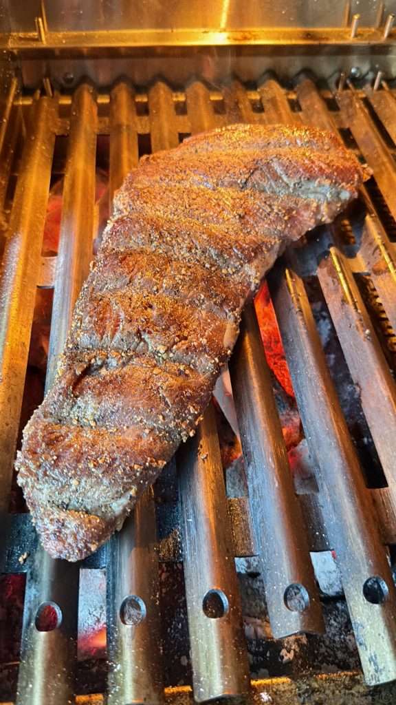 A beef tri tip on top of the super hot coals getting a flavor crust