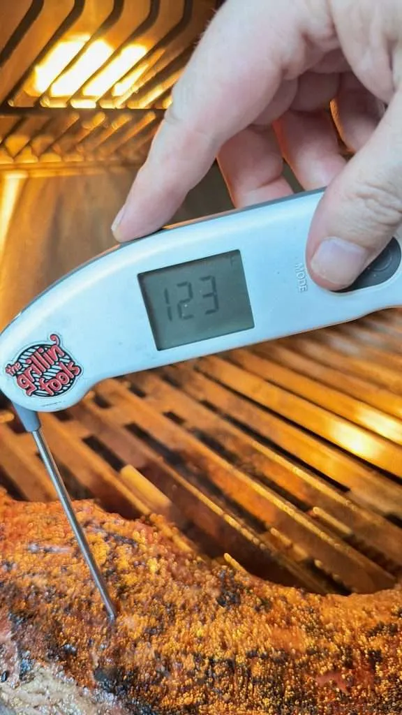A probe thermometer reading 123F in a indirect grilled tri tip