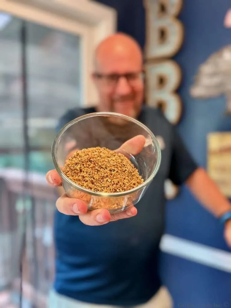 An incredibly handsome man hold a small glass bowl of beef seasoning