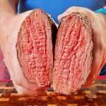A cross section of grilled tri tip, sliced in half, cooked to a beautiful medium rare