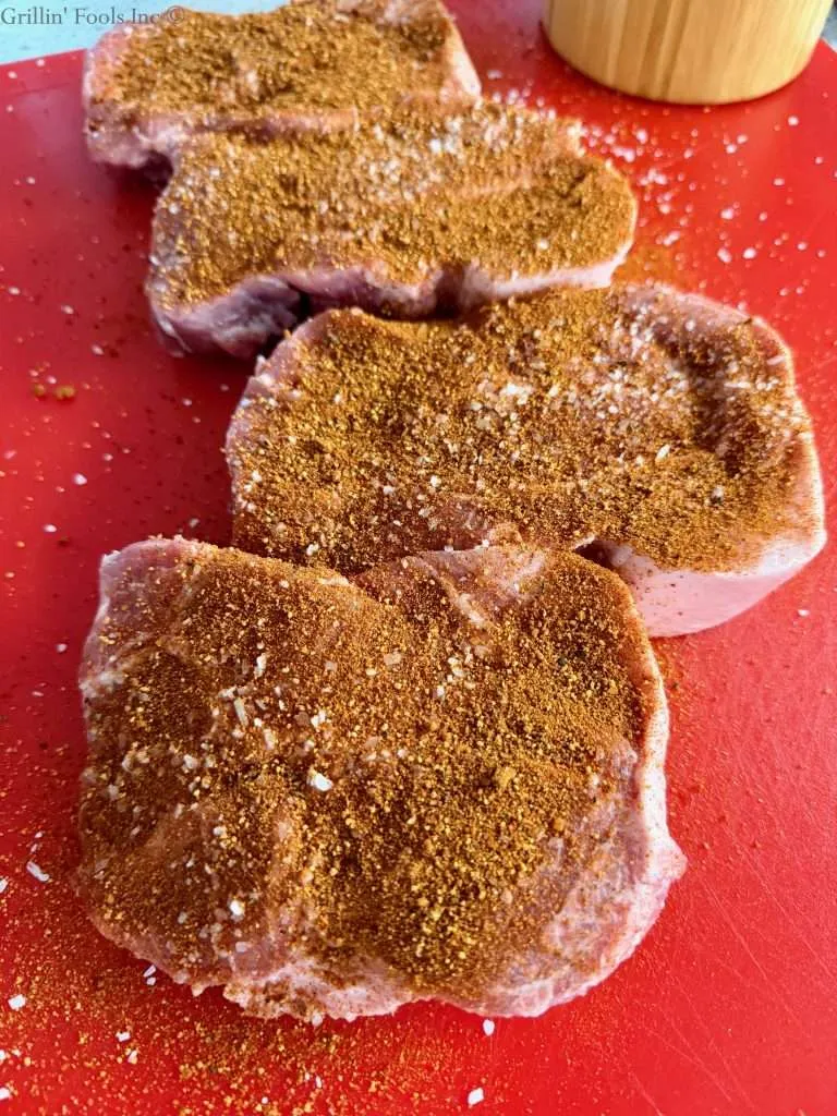 Four pork collars seasoned with salt and a BBQ rub