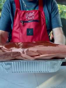 Beef Ribs wrapped in butcher paper on top of two aluminum pans