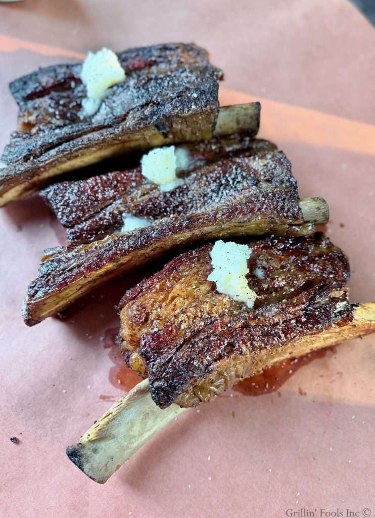 Seasoned beef ribs with three tablespoons of beef tallow on top on a sheet of butcher paper