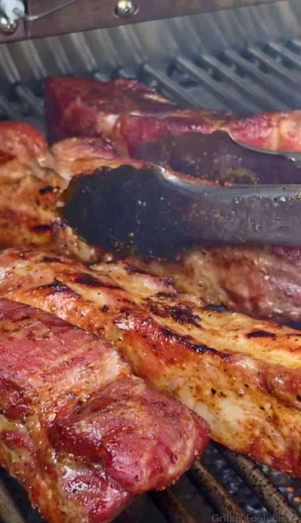 Charred country style ribs on a stainless steel grill