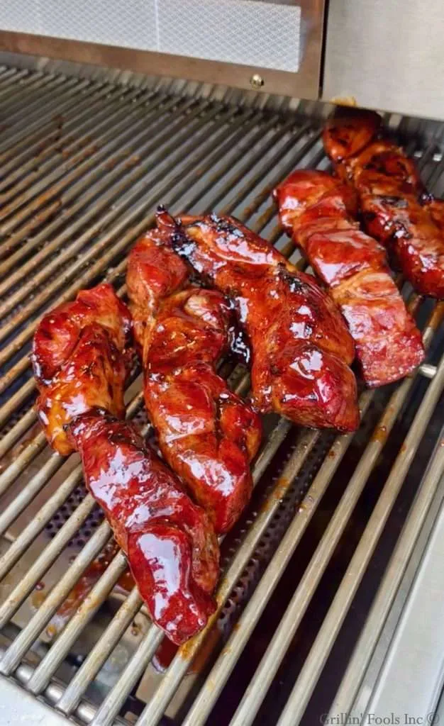 Five sauced country style ribs on a stainless steel grill