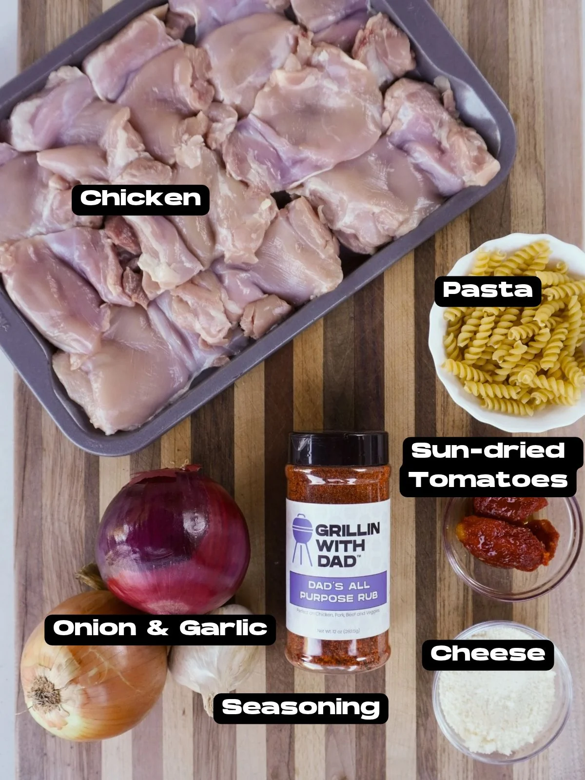 Caramelized onion and chicken pasta ingredients on a cutting board.