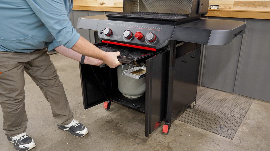 Pulling the drip pan out from the front of the Weber Genesis E-330 Stealth