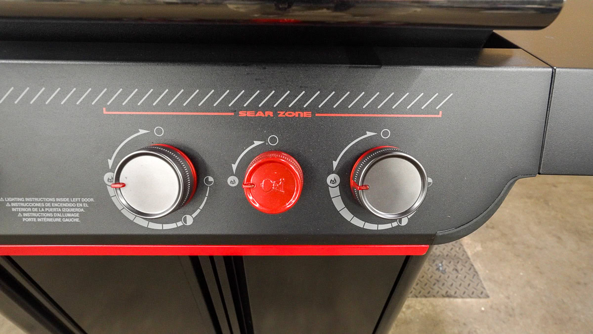 Weber Genesis E-330 Stealth control knobs with the red Sear Zone burner knob in the center