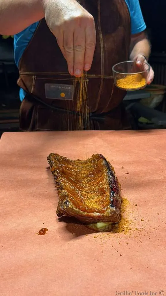 Seasoning the bone side of these smoked baby back ribs with apple butter