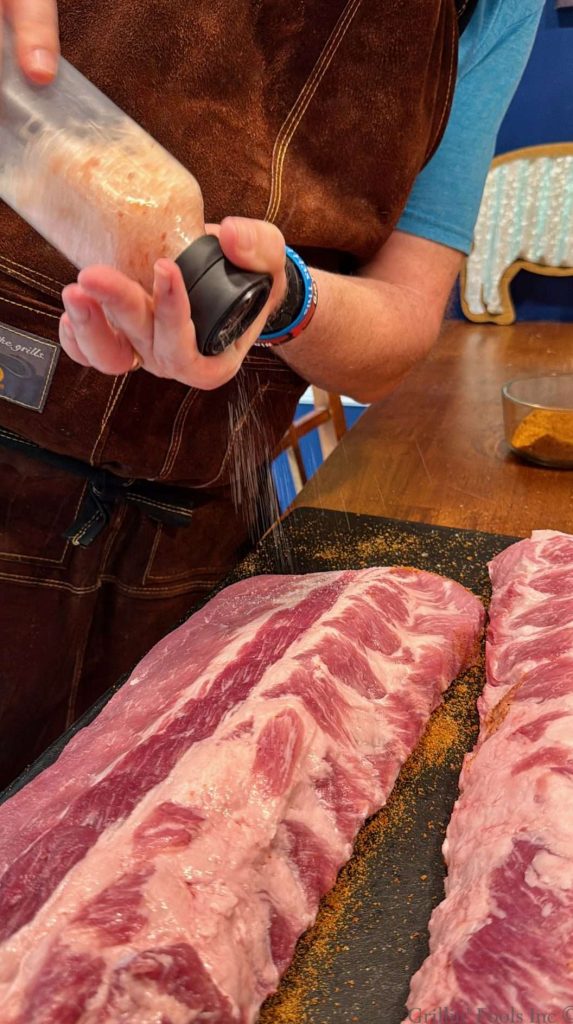 Salting the meat side of a slab of baby back ribs